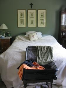 open suitcase, rumpled bed